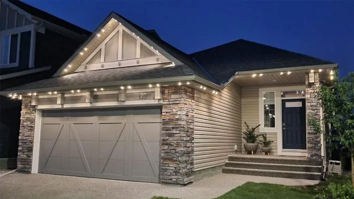 A home lit with warm-white permanent LED lighting along the roofline at dusk