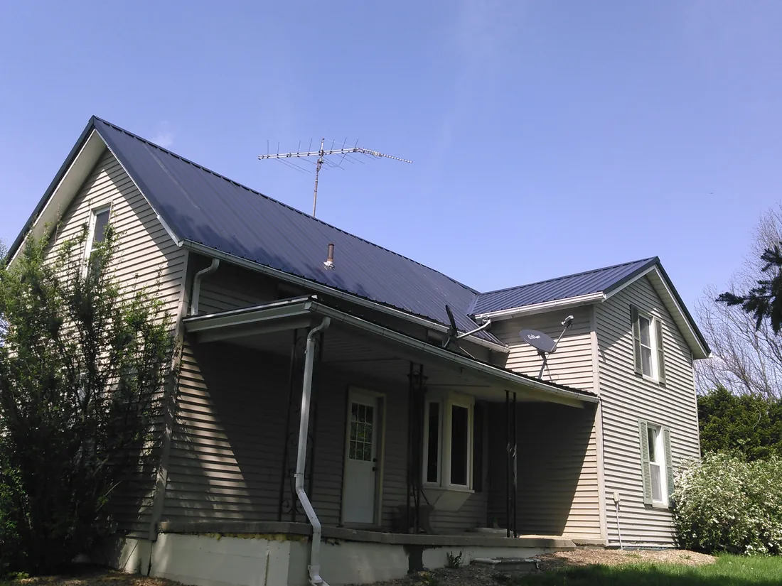 A two-story home with a gray metal roof