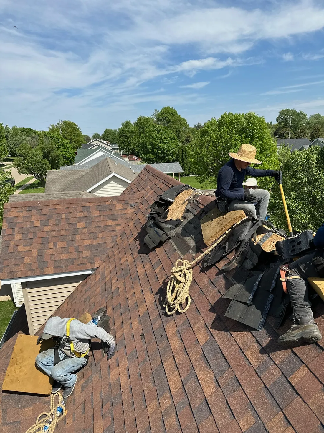 A New Summit Roofing crew member working on a shingle roof