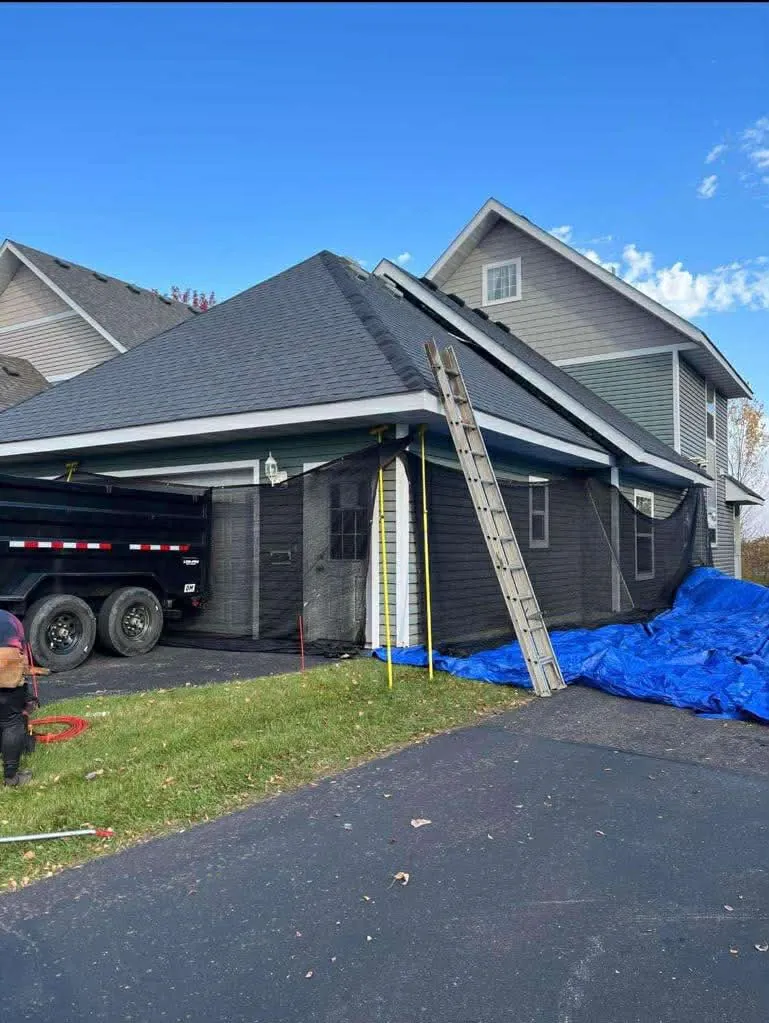 A roof replacement in progress with the New Summit Roofing trailer on site
