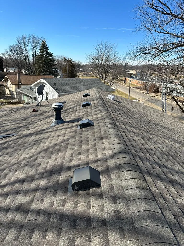 A New Summit Roofing crew member inspecting a shingle roof