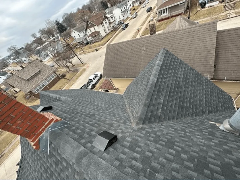 A hip roof with freshly installed shingles